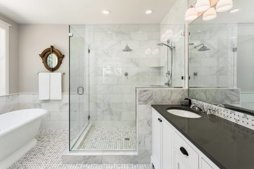 Bagno lussuoso con box doccia trasparente e parete in marmo